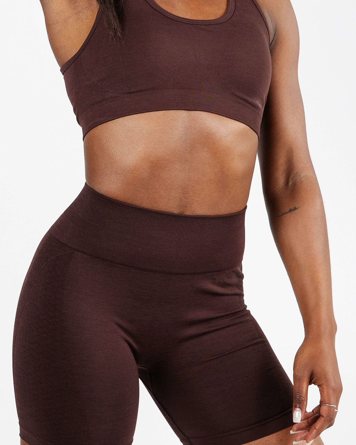 Close-up of the rich chocolate brown ribbed fabric and wide elastic band of the high support sports bra for chafe-free comfort.