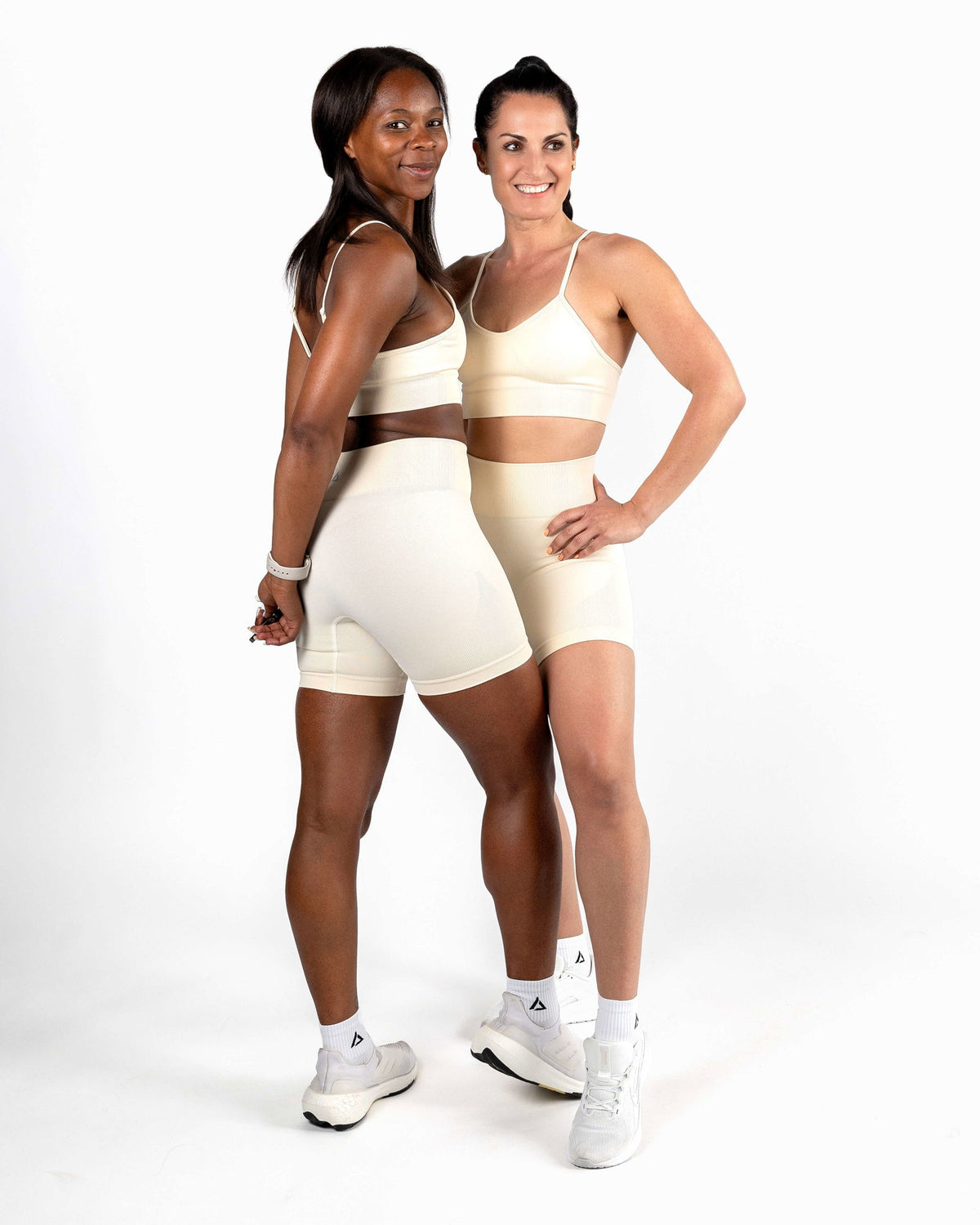 Two models wearing the Ivory Seamless Shorts and Bra set, engineered for freedom of movement in low-impact sessions like yoga or recovery.