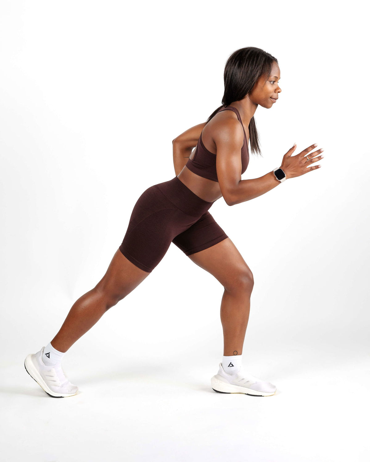 Model performing a workout movement in the Chocolate Brown Racer Back Sports Bra, showing uncompromised support and seamless construc