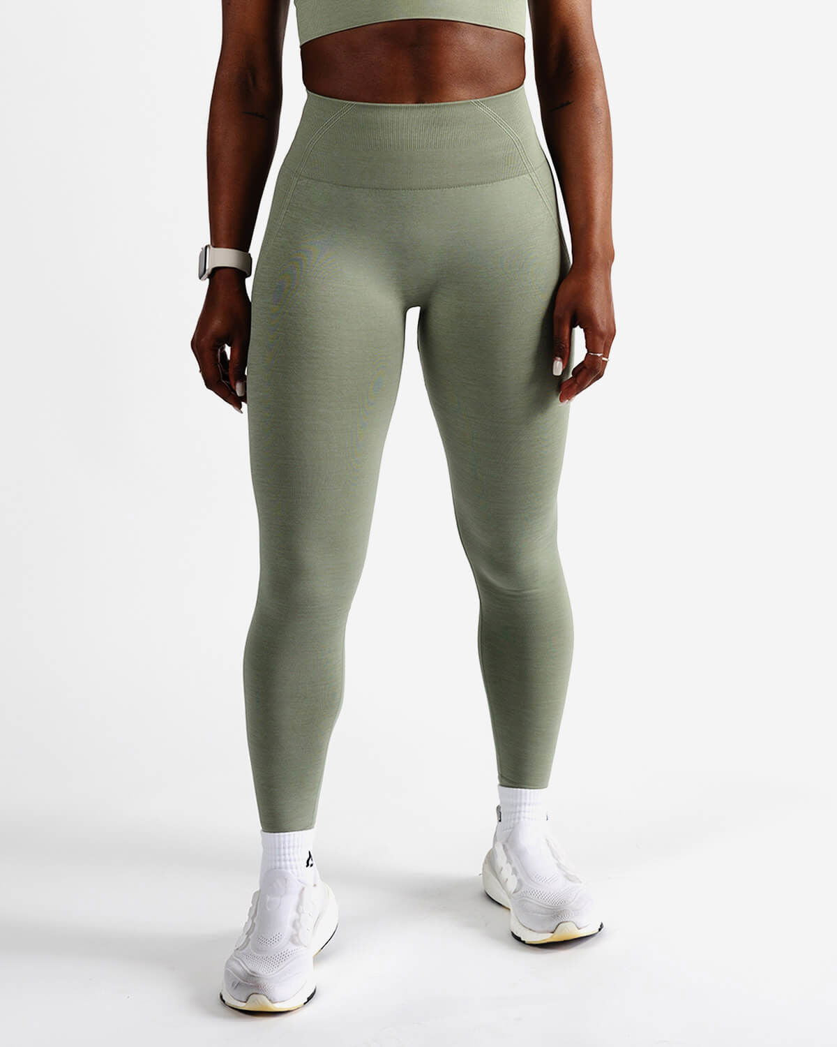 Front view of woman wearing sage green seamless leggings with high waist support.
