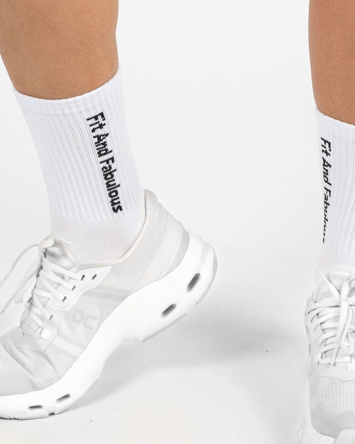 Side view of Dellaura white crew socks showing logo detail and fit.